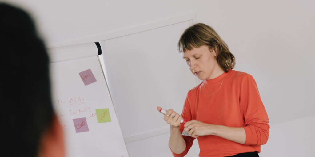 A teacher writing on a flip chart during a session