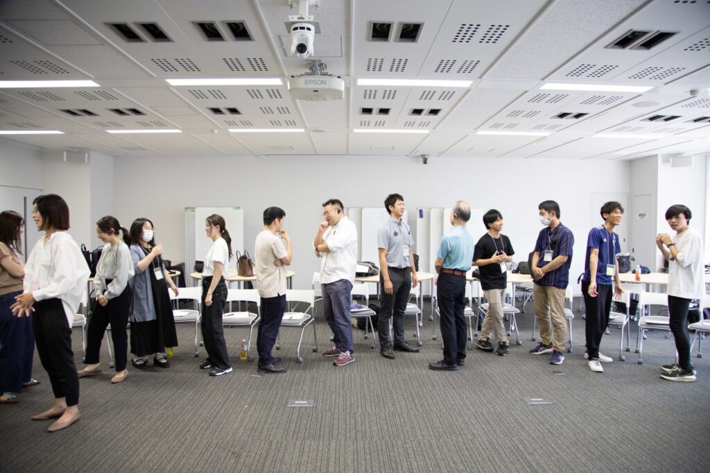 Participants talking in a bright classroom during a session